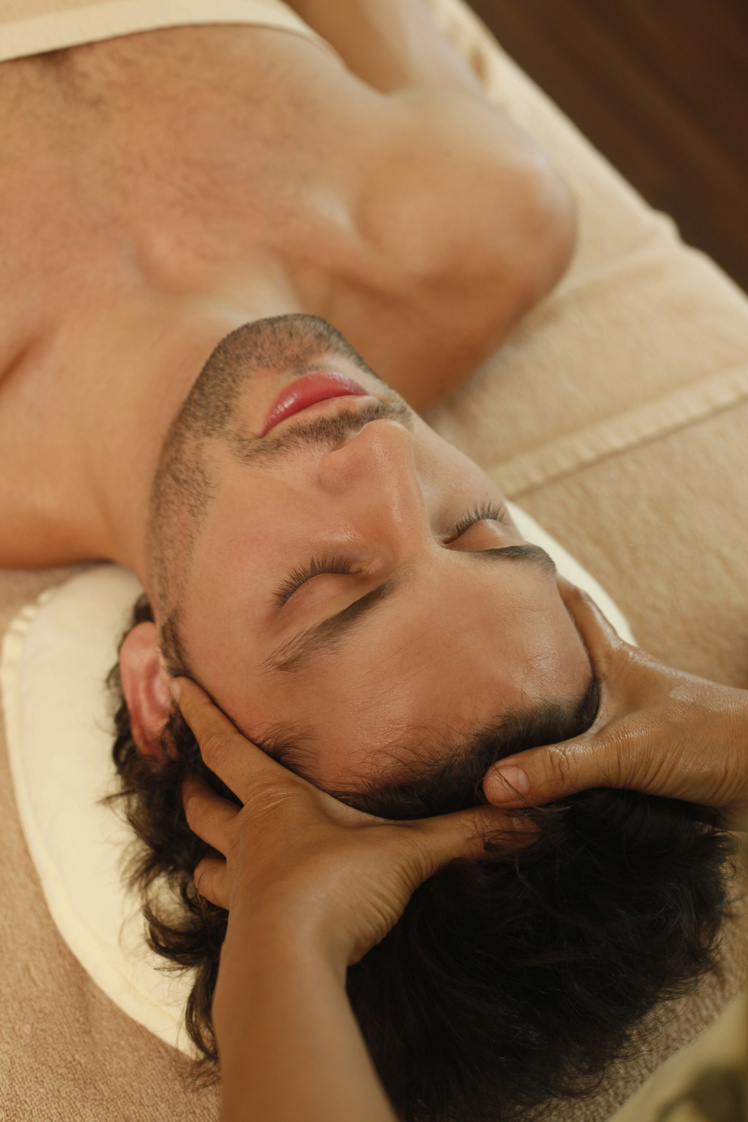 massage therapist massaging man's head